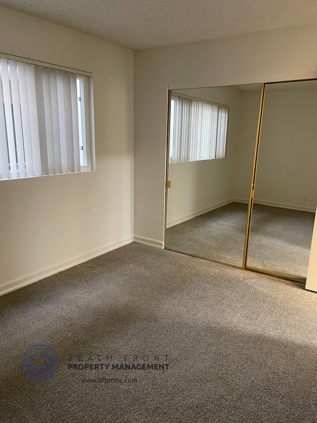 an empty room with a mirror and a window